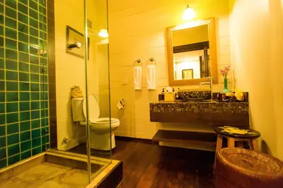 a bathroom with a toilet and a sink and a mirror at Arun Residence in Bangkok