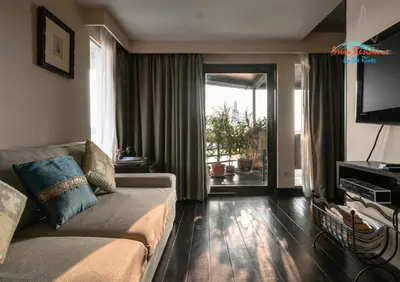 a living room with a couch and a sliding glass door at Arun Residence in Bangkok