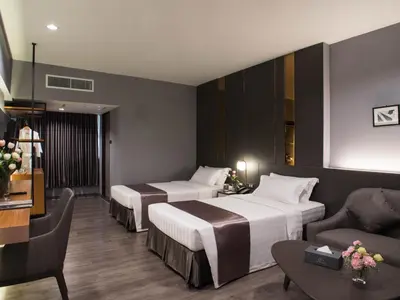 a hotel room with two beds and a couch at S.D. Avenue Hotel in Bangkok