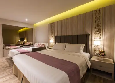 a hotel room with two beds and a living room at S.D. Avenue Hotel in Bangkok