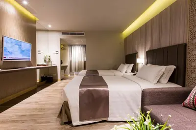 a hotel room with two beds and a couch at S.D. Avenue Hotel in Bangkok