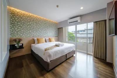 a bedroom with a large bed and a large window at Season Place in Bangkok