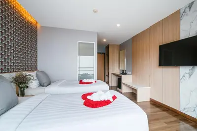 a hotel room with two beds and a flat screen tv at Season Place in Bangkok