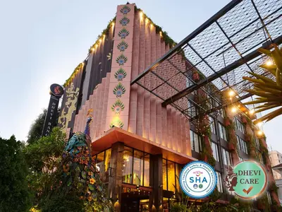 a building with a christmas tree in front of it at Dhevi Bangkok Hotel in Bangkok