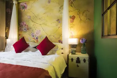 a bedroom with a bed with a floral wall at Dhevi Bangkok Hotel in Bangkok