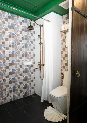 a bathroom with a toilet and a shower at Dhevi Bangkok Hotel in Bangkok