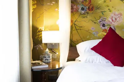 a bedroom with a bed and a table with a lamp at Dhevi Bangkok Hotel in Bangkok