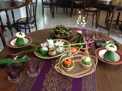 a table with plates of food and flowers on it at SSIP Boutique Dhevej Bangkok in Bangkok