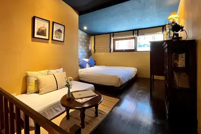 a small room with two beds and a table at Old Capital Bike Inn - SHA Certified in Bangkok