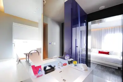 a bathroom with a sink and a large mirror at Mode Sathorn Hotel in Bangkok