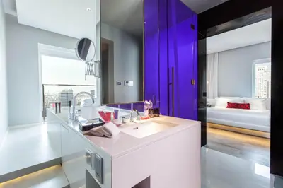 a bathroom with a white sink and a purple wall at Mode Sathorn Hotel in Bangkok