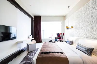 a bedroom with a large bed and a large window at Mode Sathorn Hotel in Bangkok