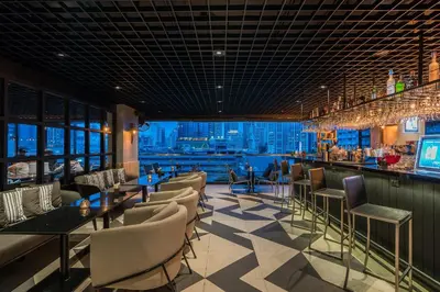 a restaurant with a bar with a view of the city at The Key Premier Hotel Sukhumvit Bangkok in Bangkok