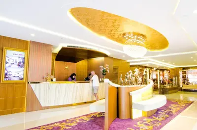 a man standing at a bar in a hotel lobby at Amaranta Hotel in Bangkok