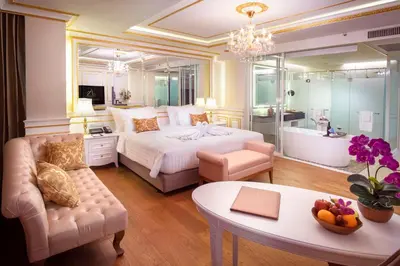 a bedroom with a bed and a table and a couch at Amaranta Hotel in Bangkok