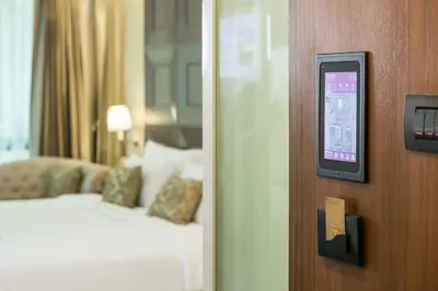 a hotel room with a bed and a door with a phone at Amaranta Hotel in Bangkok
