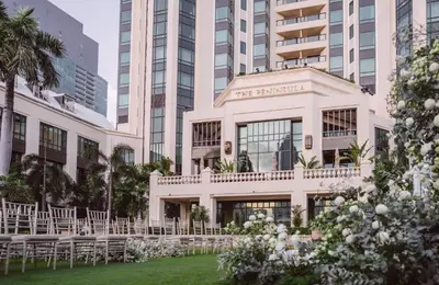 a wedding venue with white tables and chairs in front of a building at The Peninsula Bangkok in Bangkok