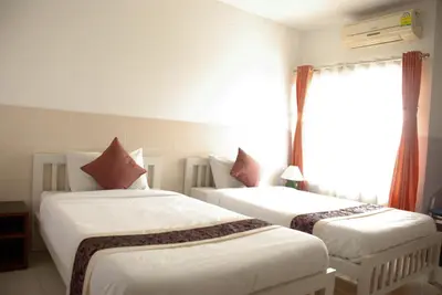 two beds in a room with a window at Ratchada 17 Place in Bangkok