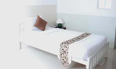 a white bed in a white room with a white bedspread at Ratchada 17 Place in Bangkok