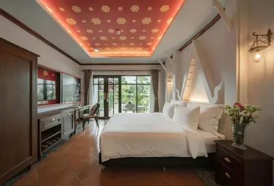 a bedroom with a bed and a desk and a television at Kasayapi Hotel in Bangkok