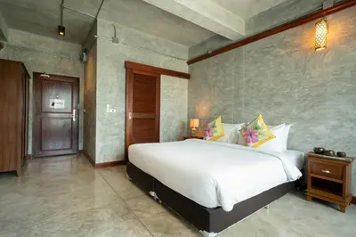 a bedroom with a large white bed and a wooden door at Kasayapi Hotel in Bangkok