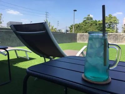 a blue picnic table with a glass vase on it at Kasayapi Hotel in Bangkok