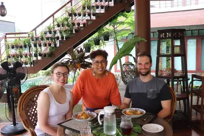 three people sitting at a table in a restaurant at Kasayapi Hotel in Bangkok