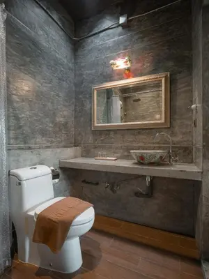 a bathroom with a toilet and a sink at Kasayapi Hotel in Bangkok