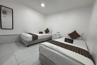 a room with two beds and a mirror at Papa Ji Hotel and Restaurant in Bangkok