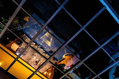 a reflection of a yellow bus in a window at The LOL Elephant Hostel in Bangkok