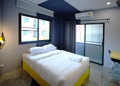 a bedroom with a large white bed with two pillows at Ratch66 Huai Khwang MRT in Bangkok