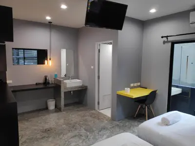 a hotel room with a sink and a mirror at Ratch66 Huai Khwang MRT in Bangkok