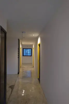 an empty hallway with white walls and yellow doors at Ratch66 Huai Khwang MRT in Bangkok