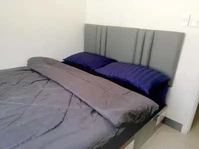 a bed with purple pillows in a white room at NIDO Guest House in Ban Bang Phang
