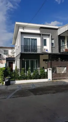 a white house with a fence in front of it at NIDO Guest House in Ban Bang Phang