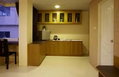 a kitchen with wooden cabinets and a microwave at Loft 77 in Bangkok