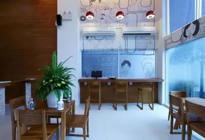 a dining room with wooden tables and chairs and a screen at Loft 77 in Bangkok