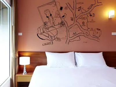 a bedroom with a bed with a drawing on the wall at Loft 77 in Bangkok