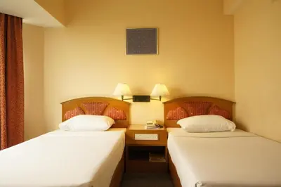 a hotel room with two beds and a telephone at Bangkok City Inn in Bangkok