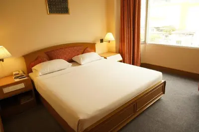 a large bed in a hotel room with a window at Bangkok City Inn in Bangkok