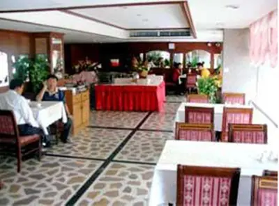 a dining room with people sitting at tables in a restaurant at Bangkok City Inn in Bangkok