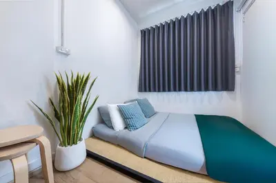 a bedroom with a bed and a potted plant at Platinum Deluxe Shopping Apartments in Bangkok