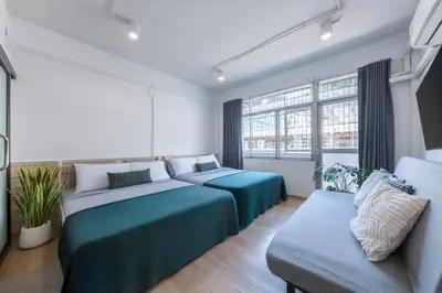 a bedroom with two beds and a couch at Platinum Deluxe Shopping Apartments in Bangkok