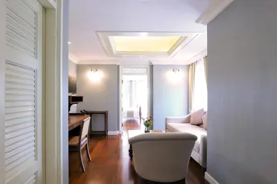 a living room with a couch and a chair and a desk at Hiranyakul House Riverside in Bangkok