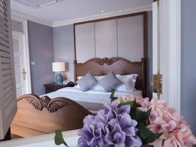 a bedroom with a large canopy bed with purple flowers at Hiranyakul House Riverside in Bangkok