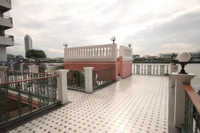 a balcony of a building with a view of the water at Hiranyakul House Riverside in Bangkok