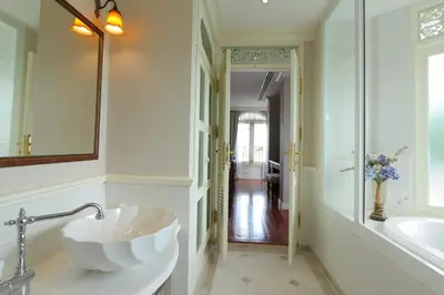a bathroom with a large sink and a mirror at Hiranyakul House Riverside in Bangkok