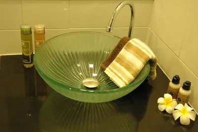 a green glass bowl with a towel in a bathroom at Bangkok Living in Bangkok