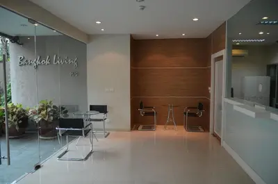 a lobby with chairs and a table in a building at Bangkok Living in Bangkok