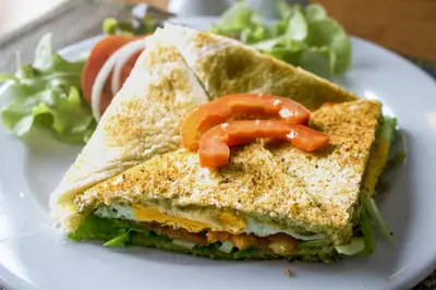 a sandwich with peppers on a white plate at GM Serviced Apartment in Bangkok